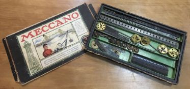 An early Meccano box set containing two trays of strips, wheels, cogs, bolts, screws etc,