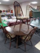 An Ercol stained elm drop leaf dining table and a set of four high back spindle dining chairs