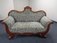 A continental mahogany scroll arm settee in floral upholstery