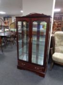 A contemporary double door display cabinet with mirrored back,