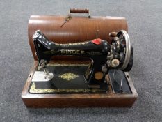 A vintage Singer hand sewing machine in carry case