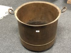 A large copper twin handled cooking pot