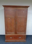 An antique pine double door wardrobe fitted a drawer beneath