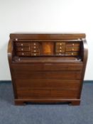 An early 20th century mahogany barrel front bureau