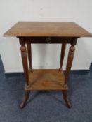 An early 20th century continental oak two tier occasional table fitted a drawer