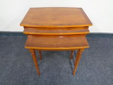 A nest of three inlaid yew wood table together with an inlaid mahogany television cabinet on raised