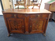A late 19th century mahogany serpentine front double door sideboard fitted two drawers on scroll
