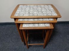 A nest of three mid 20th century teak tile top tables