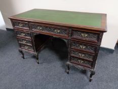 A 19th century carved mahogany twin pedestal writing desk fitted nine drawers with green leather