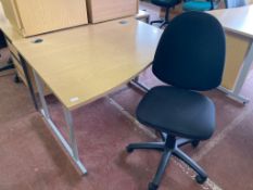 A light oak effect desk, width 120 cm, together with a swivel chair.