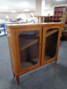 A continental mahogany double door display cabinet in raised legs
