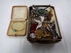 A jewellery casket containing assorted costume jewellery to include enamel brooch, Art Deco brooch,