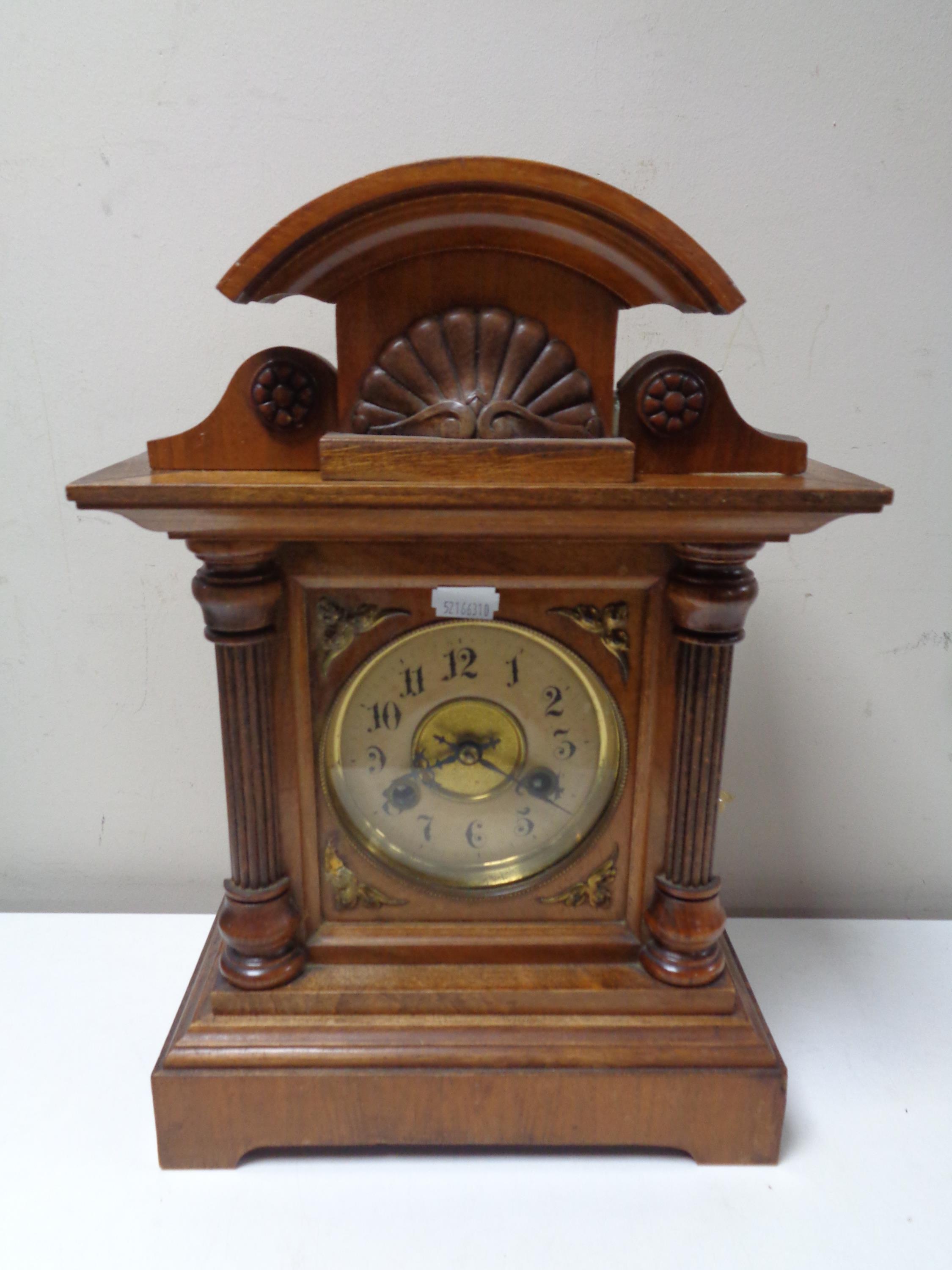 A beech cased eight day mantel clock with brass dial