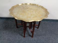 A folding eastern brass topped table