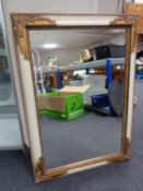 A contemporary white and gilt framed bevelled overmantel mirror