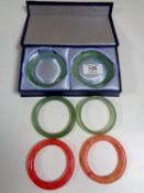 Four Chinese green jadeite bangles, together with two red stone bangles.