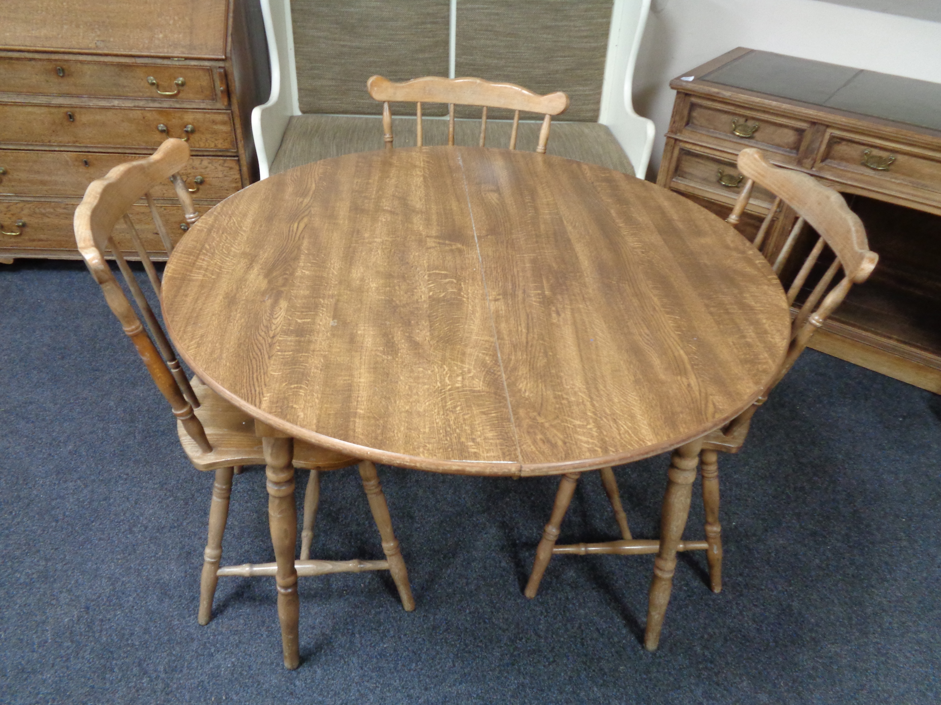 A circular Dinette kitchen table together with three rail back chairs