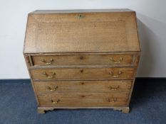 A Georgian oak writing bureau fitted four drawers with brass drop handles