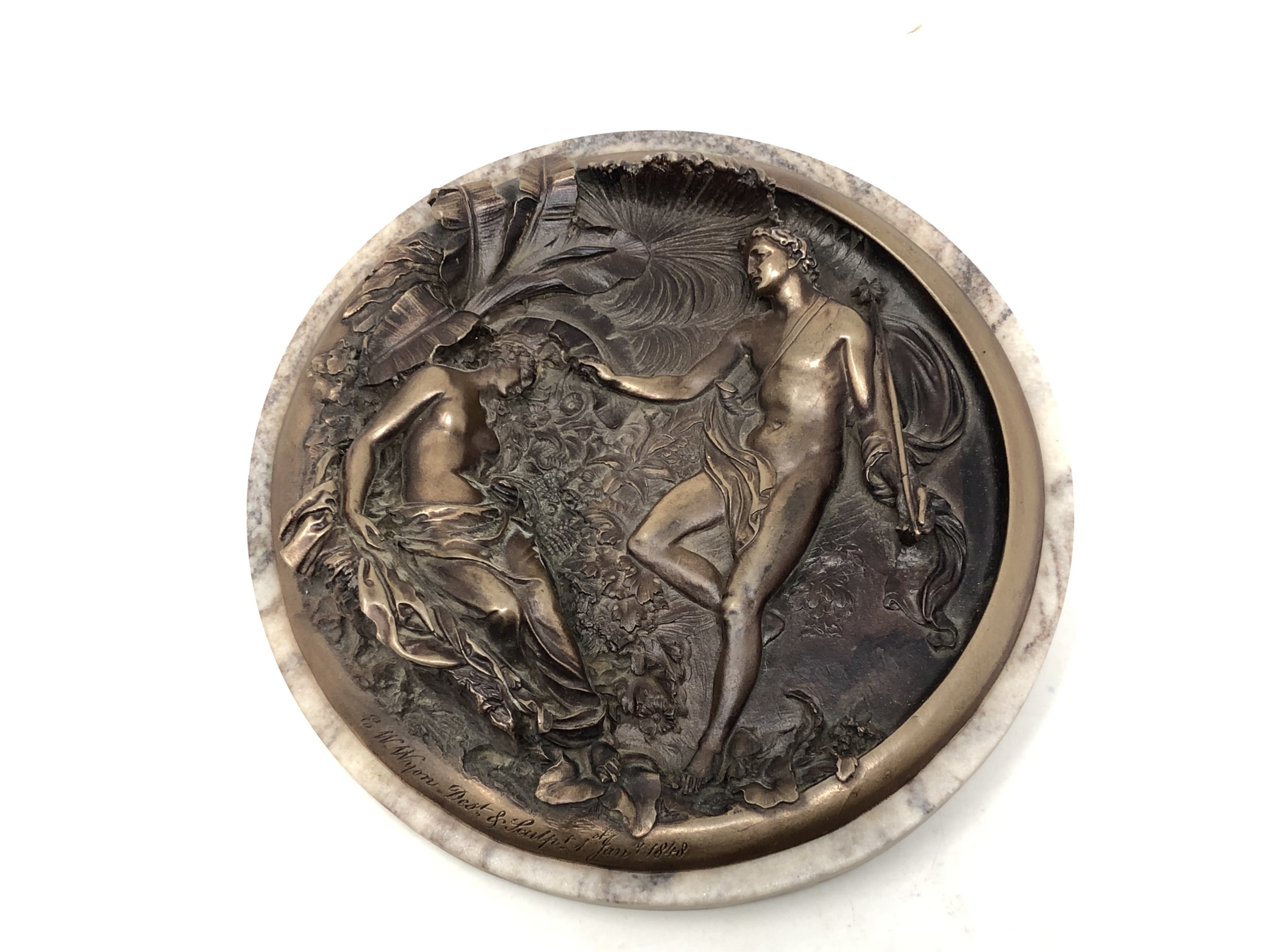 A moulded roundel depicting a classical scene,