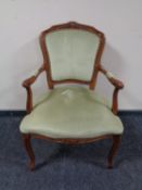 A carved beech salon armchair upholstered in a green dralon
