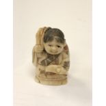 A carved Chinese bone netsuke - Elderly woman carrying a sack