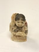 A carved Chinese bone netsuke - Elderly woman carrying a sack