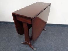 An inlaid mahogany drop leaf table on brass capped feet