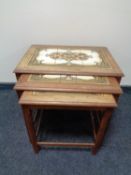 A nest of three mid 20th century teak tile top tables