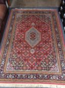 A Tabriz rug of geometric design with central medallion on red ground