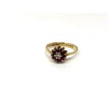 An 18ct gold ruby and diamond cluster ring, size O. CONDITION REPORT: 2.