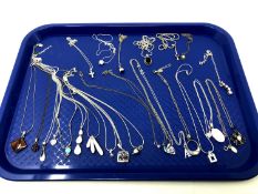 Approximately 25 silver pendants on chains.