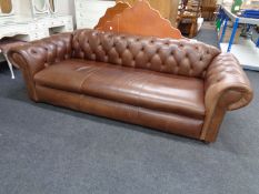 A brown buttoned leather three seater Chesterfield settee
