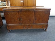 An Edwardian oak triple door sideboard fitted two drawers