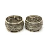 A pair of Indian silver napkin rings depicting goats, lions, hares and dogs.