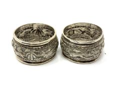 A pair of Indian silver napkin rings depicting goats, lions, hares and dogs.
