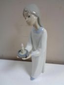 A Lladro figure of a girl in nightdress with candle.