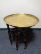 A folding eastern brass topped table