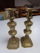 A pair of antique brass candlesticks