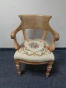 An antique pine armchair with tapestry upholstered seat