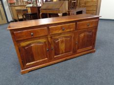 An eastern hardwood triple door sideboard fitted three drawers