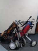 Three folding golf trolley and two golf bags containing assorted irons and drivers to include