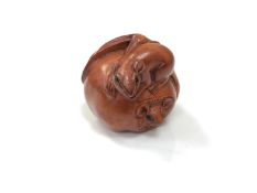 A carved Chinese hardwood netsuke - Rats eating a fruit