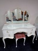 A shaped white and gilt dressing table with triple mirror and stool