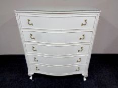 A white and gilt serpentine fronted five drawer chest