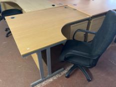 A light oak effect desk, width 145 cm, together with three drawer chest and black swivel armchair.