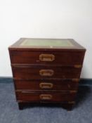 A ship's style four drawer chest with tooled leather inset panel