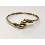A 9ct gold dolphin bangle set with diamonds CONDITION REPORT: 7.