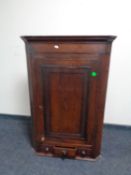 A George III hanging oak corner cupboard