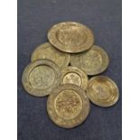 A box containing brass wall plaques, tapestry depicting a coat of arms,