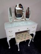 A white and gilt dressing table with triple mirror and stool